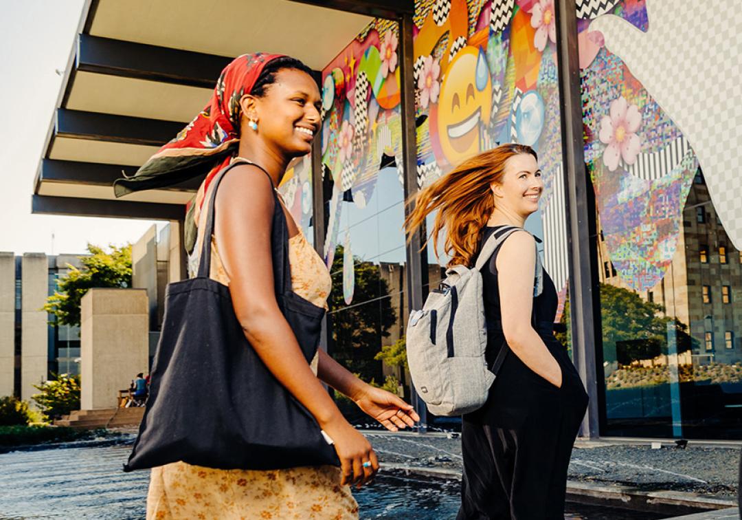 Two women walking into UQ Art Museum