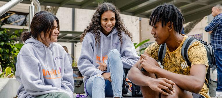 3 indigenous students sitting and talking.