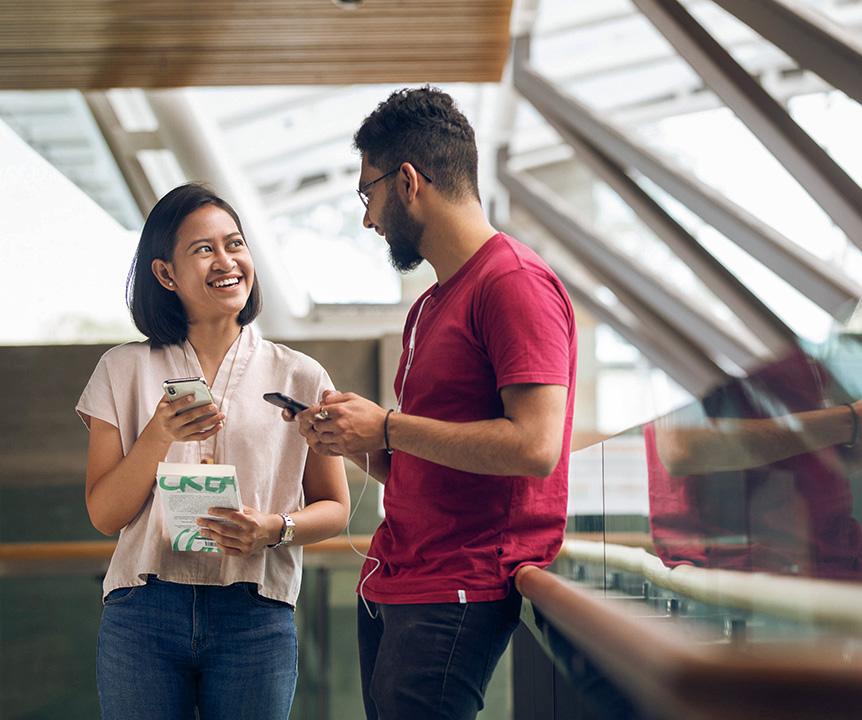 Two students exchanging mobile phone numbers