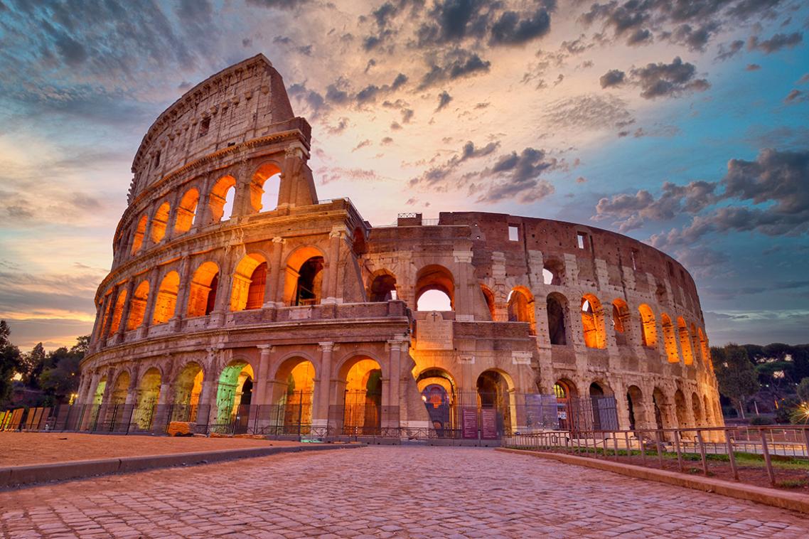 The Colosseum in Rome, bathed in golden light from the sunset
